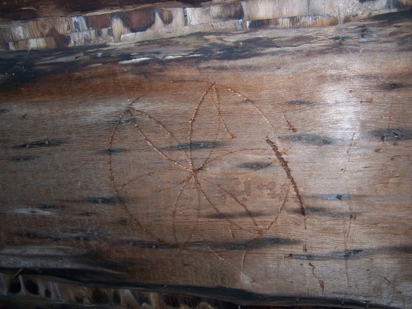 Signature of timber frame builders etched in restored wood