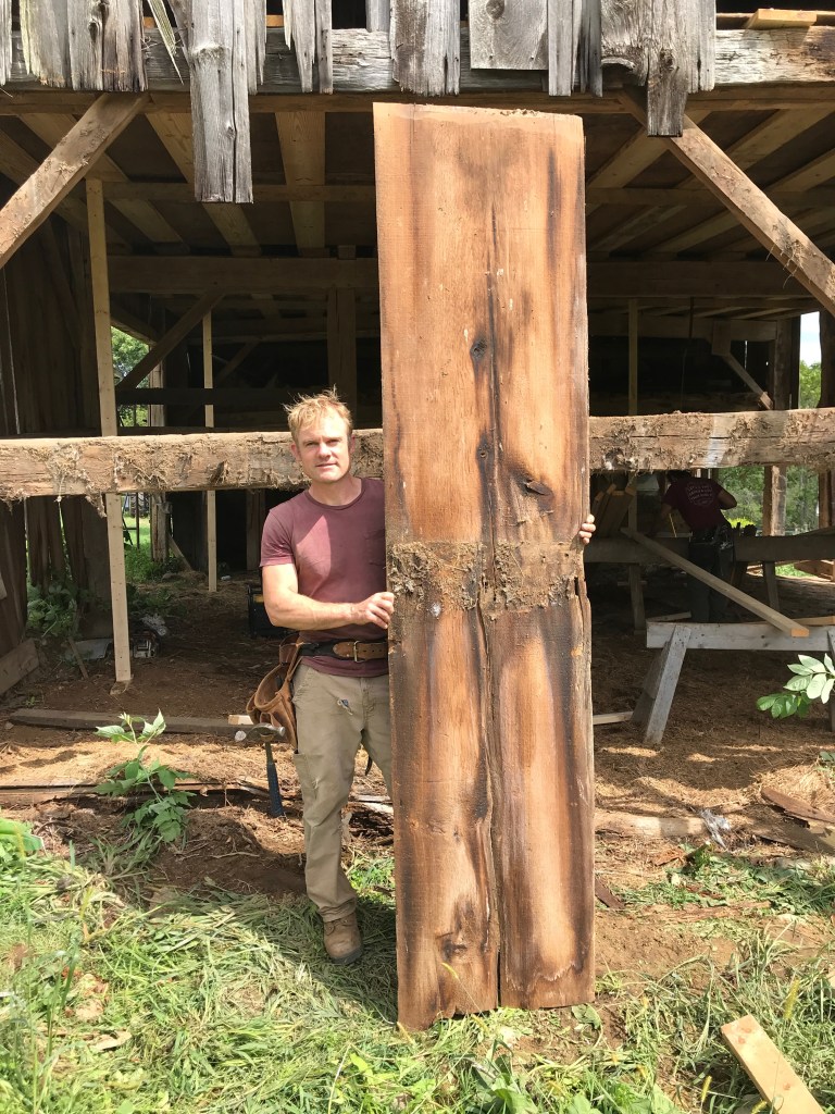 Luke Larson from Green Mountain Timber Frames with wide siding board